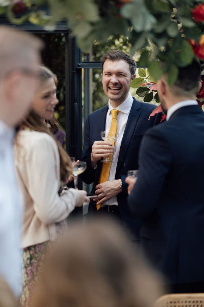 guests talking and laughing during the reception in a beautiful greenhouse