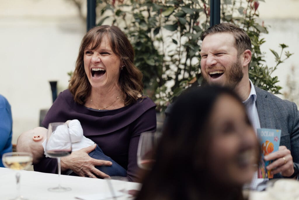 mother of the bride and her older son laughing together during the wedding reception at the Greenhouses in London