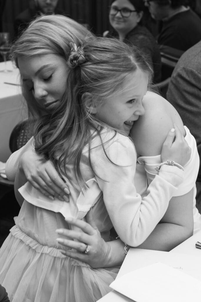 bride embraces step-daughter after she has done her speech lovingly