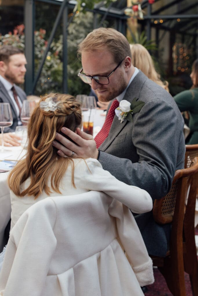 father touches his daughter lovingly on the cheek after listening to her speech