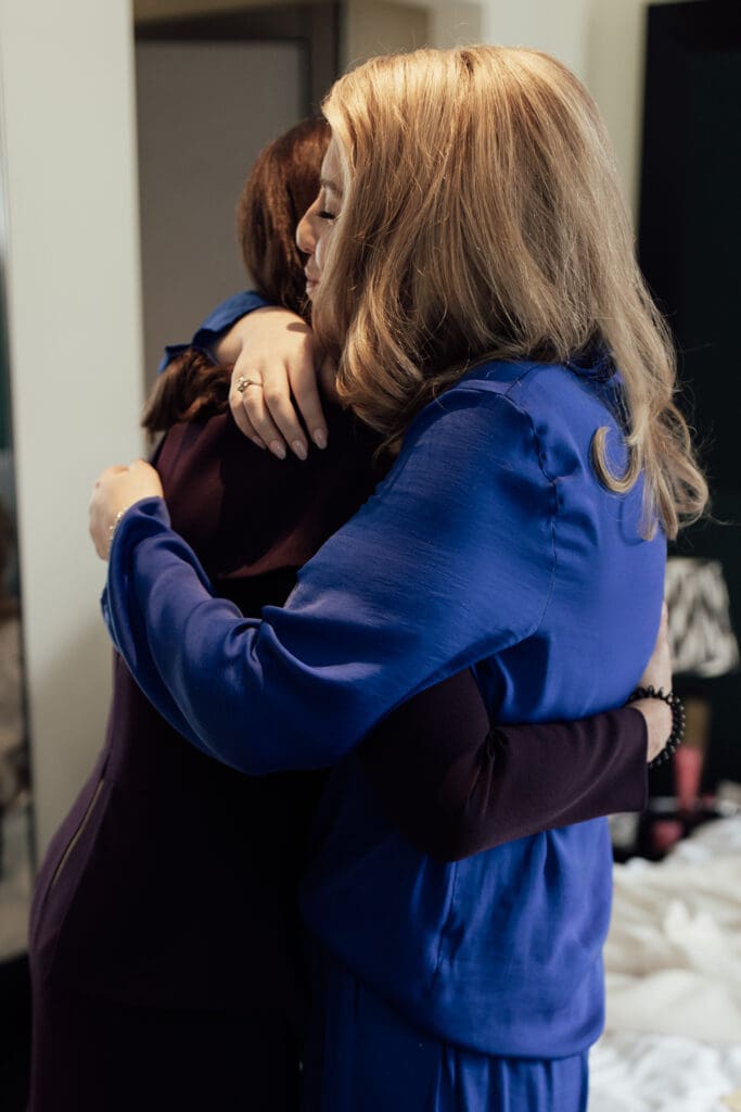 bride sharing an emotional hug with mother while getting ready at Holmes Hotel London wedding morning