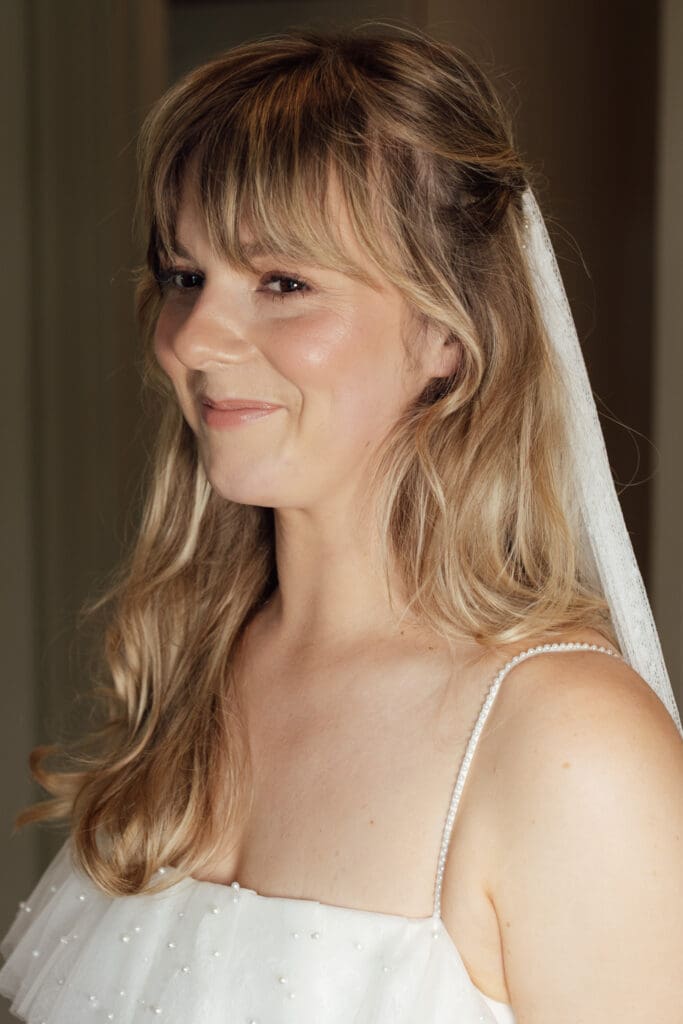 Close-up portrait of bride wearing veil and wedding dress, smiling before ceremony at Stockton House, Shropshire