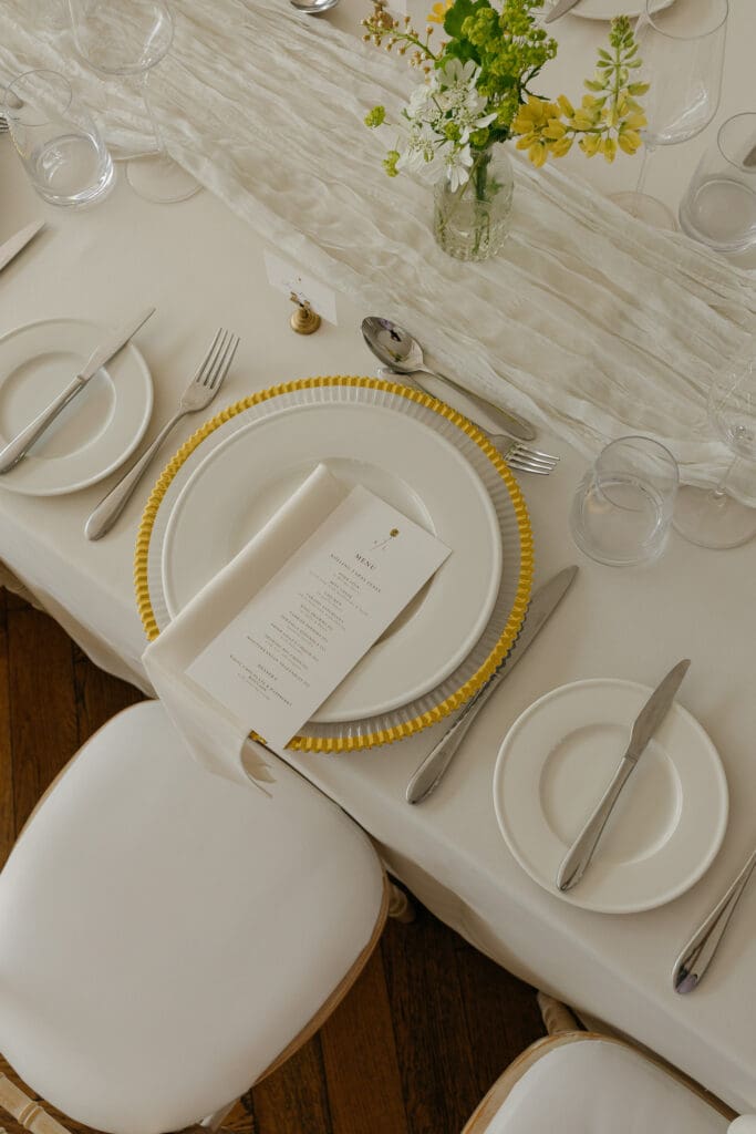 Overhead view of wedding table setting with menu, plates, cutlery and flowers at Stockton House, Shropshire