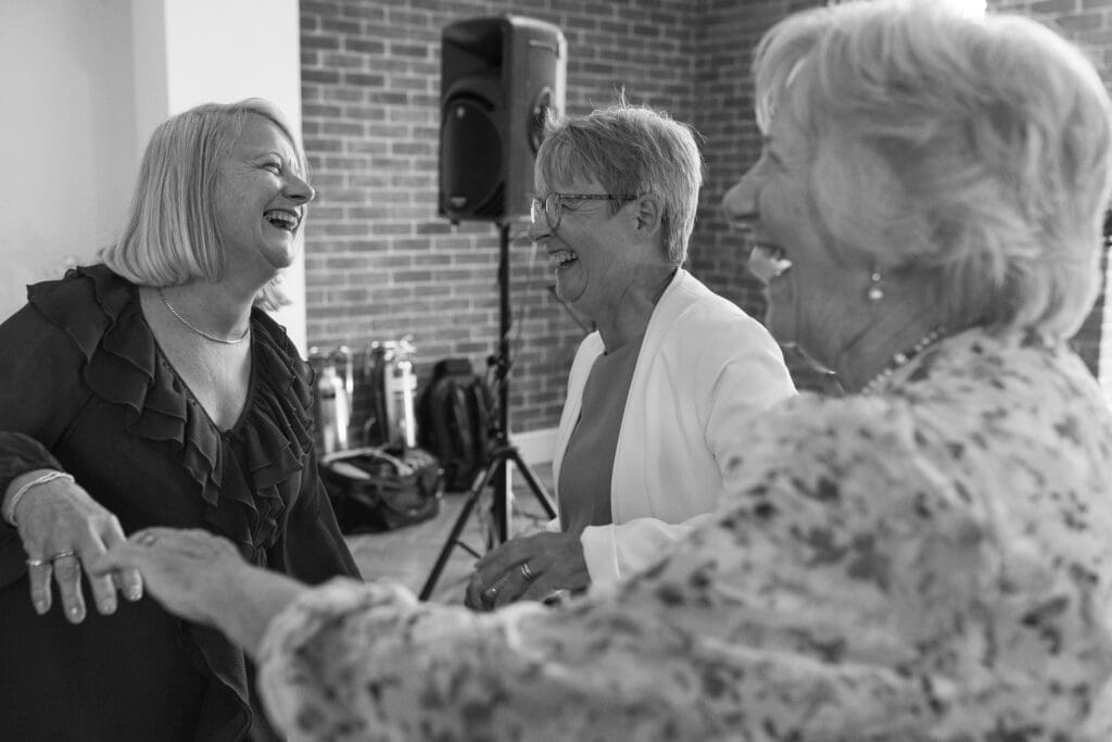 Candid moment of older wedding guests laughing and dancing together during reception at Stockton House Shropshire