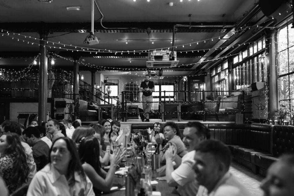 Guests applauding during speeches at The Depot wedding reception in London.
