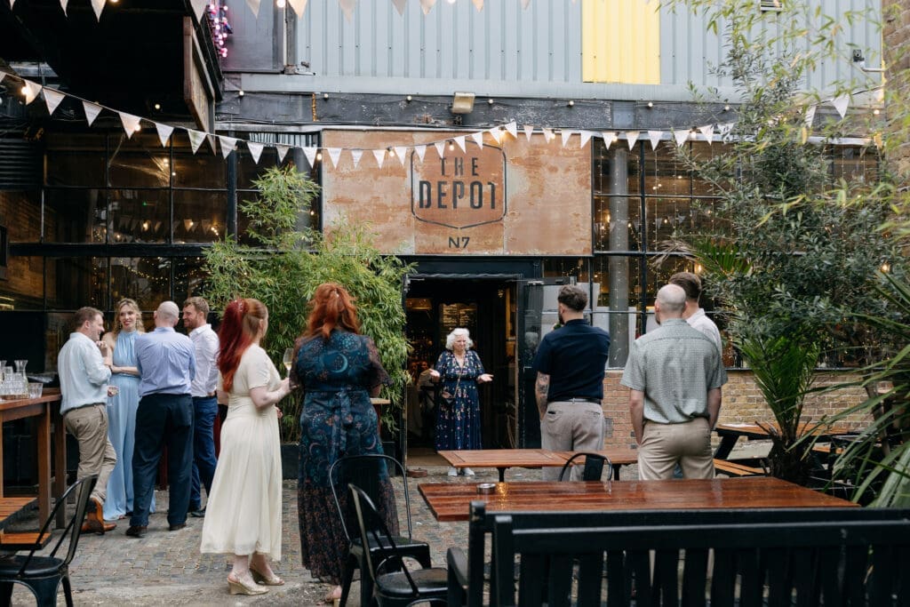 Guests gathered in The Depot courtyard during a relaxed wedding celebration in London.