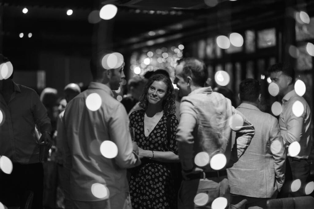 Guests chatting beneath fairy lights during an evening wedding reception at The Depot.
