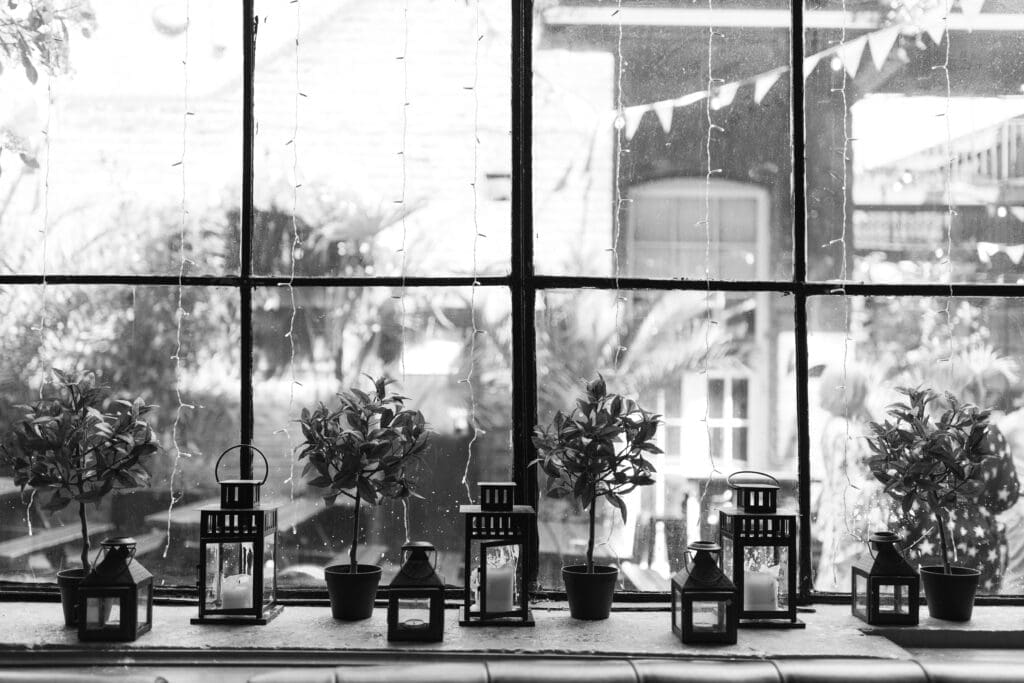 Industrial window with lanterns, potted plants and fairy lights at The Depot wedding venue.