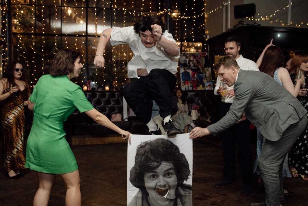 Guest jumping through a game on the dance floor during a wedding celebration at The Depot.