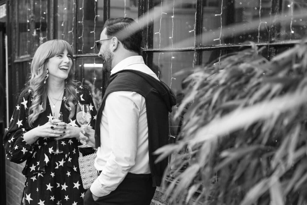 Guest laughing during drinks reception outside The Depot wedding venue in London.