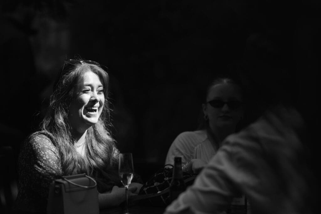 Guest laughing in sunlight during drinks reception at The Depot wedding celebration.